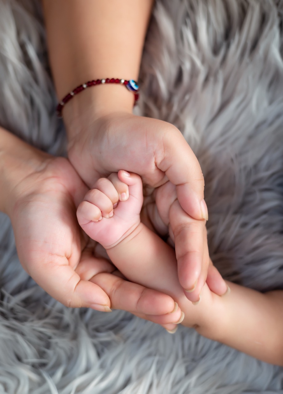parents holding baby hand photography