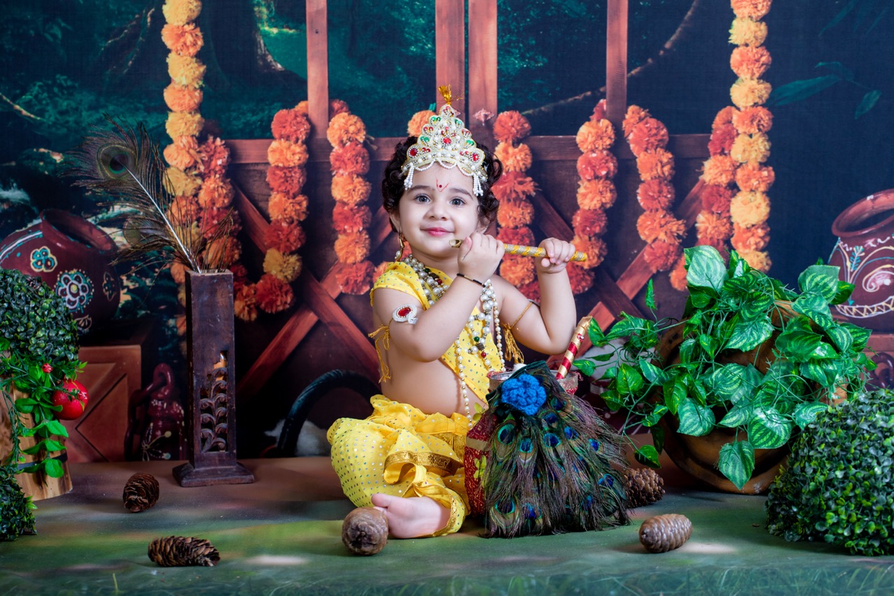 Janmashtami baby photoshoot — infant in Krishna costume playing flute